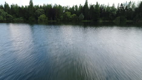 Fast-drone-flight-over-a-lake-in-France-with-trees-in-background.